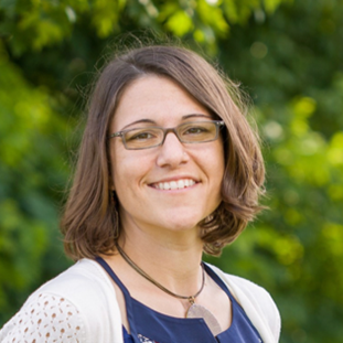 A woman smiling in an outdoor portrait.