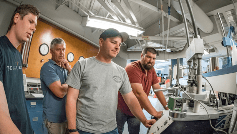 Norwich University Students working a CnC machine