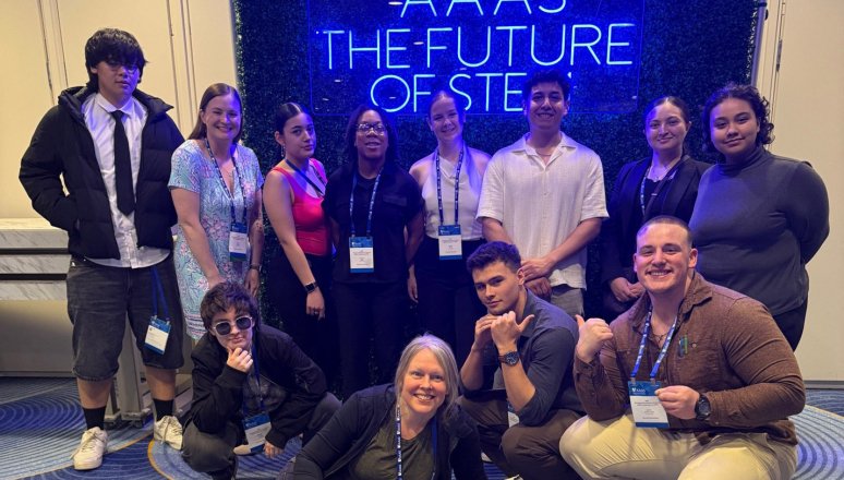 Group of students and staff pose in front of an AAAS The Future of STEM sign.