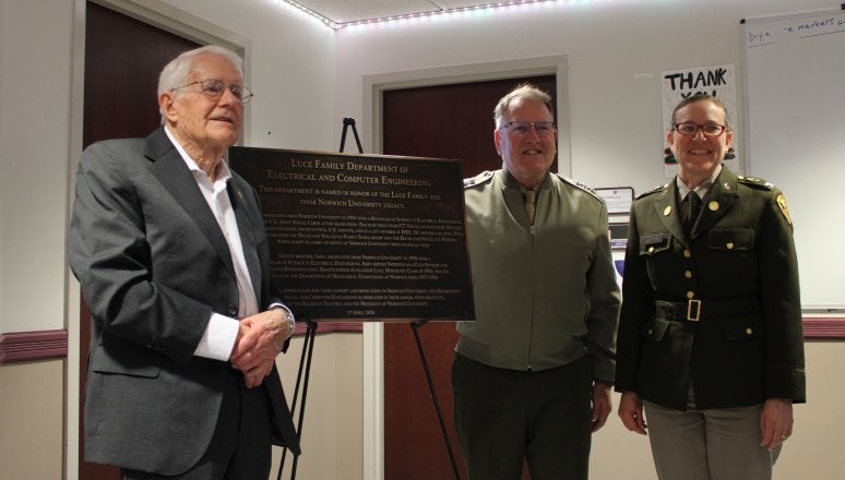 Three people stand beside a plaque for the Luce Family Department of Electrical and Computer Engineering.