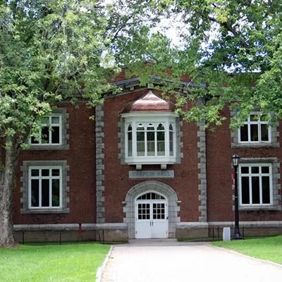 Chaplin Hall's brick facade features a white entrance, arched windows, and trees.